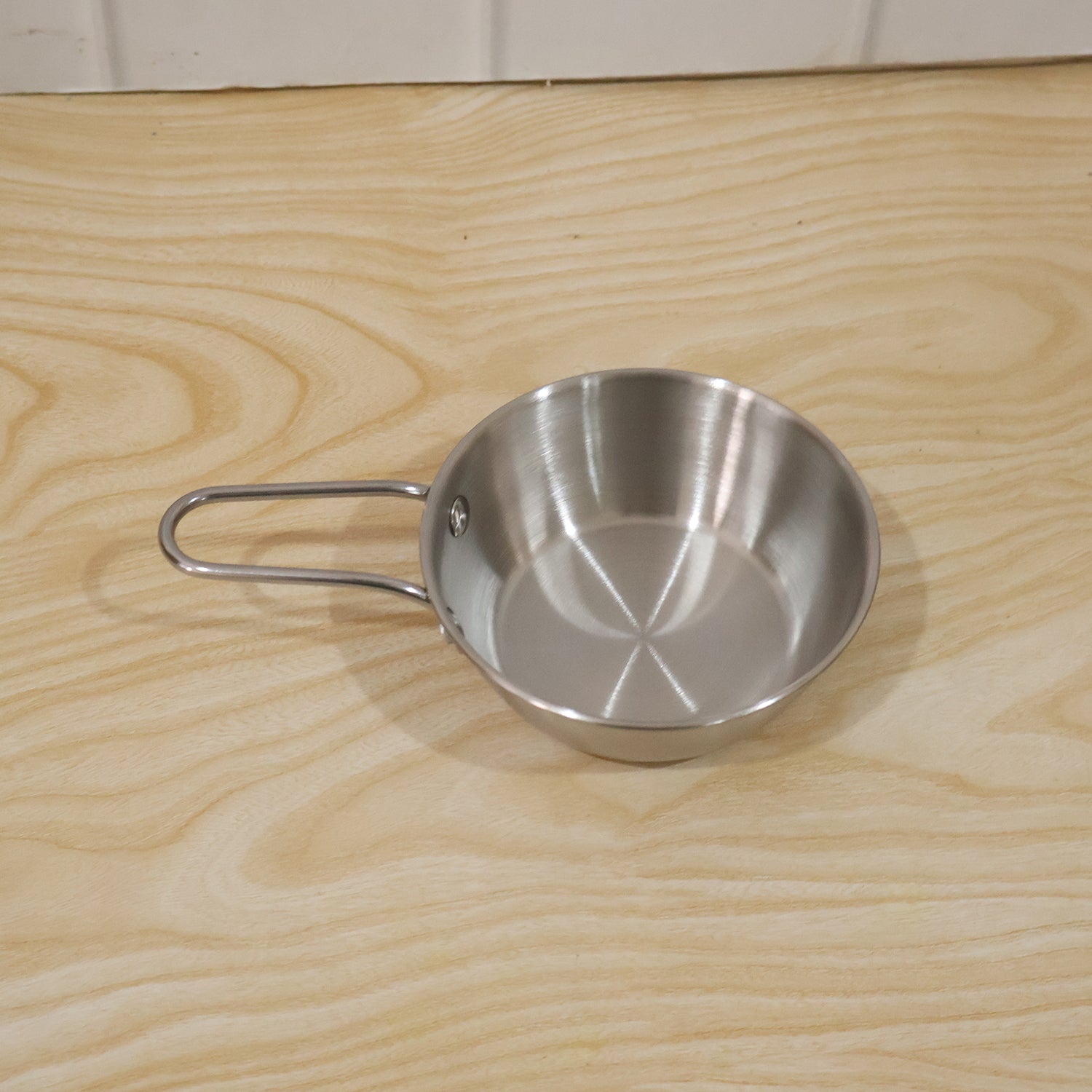 Wukusy stainless steel small tadka pan with long handle, 11 cm, used for tempering spices and cooking in the kitchen.