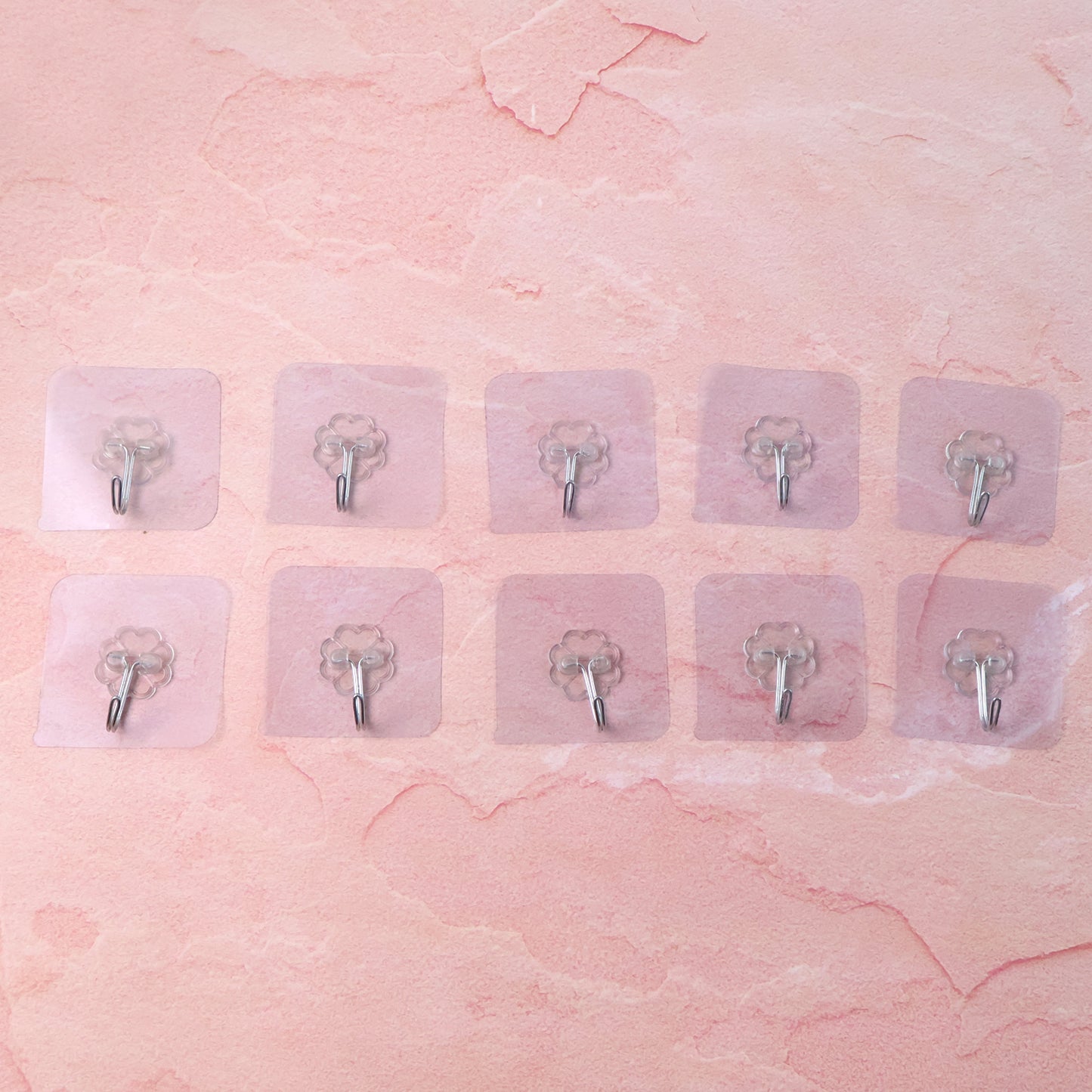 Set of 10 Wukusy heavy-duty flower adhesive wall hooks for home improvement, showing sturdy hooks attached to a wall.