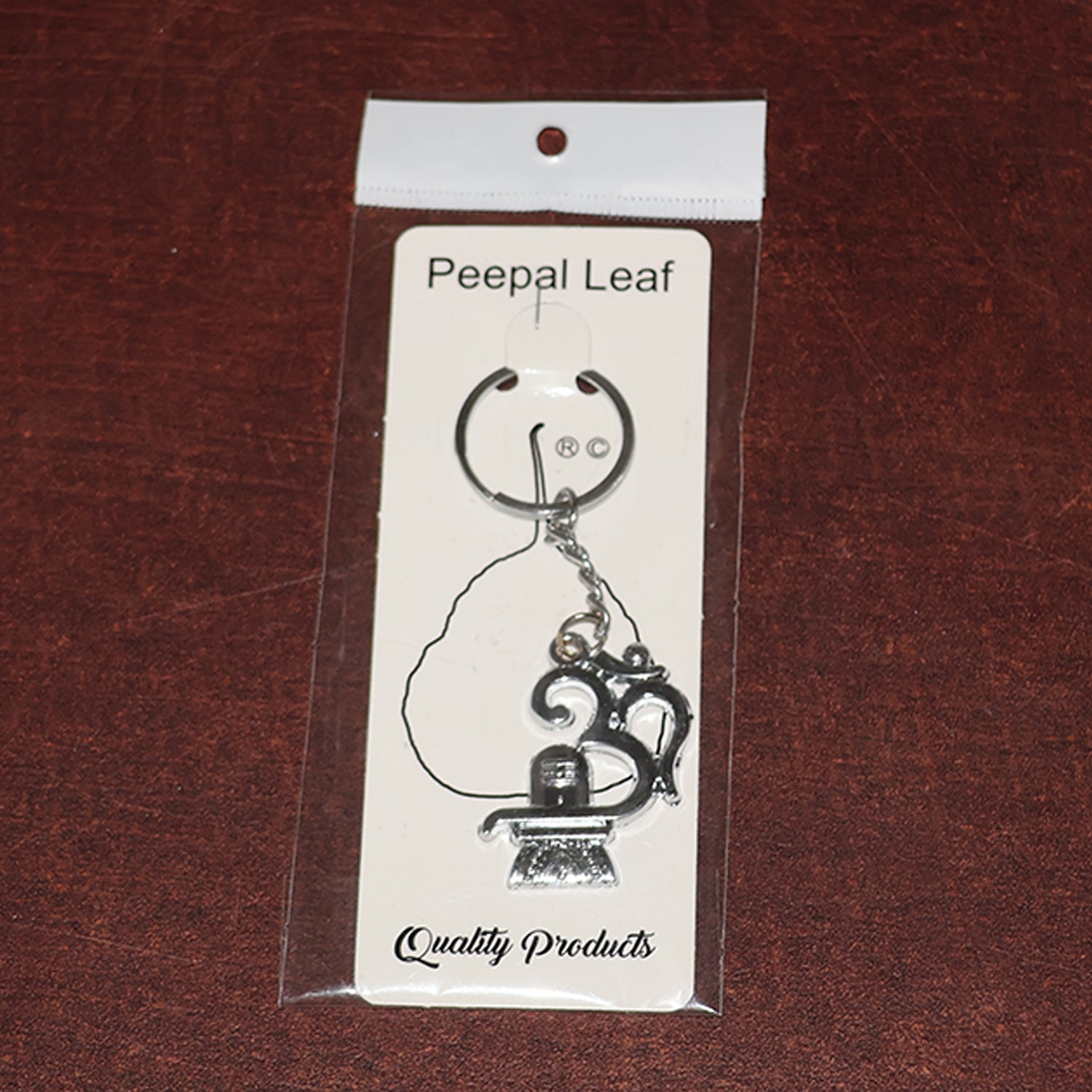 Wukusy Om with Shivling metal keychain featuring intricate design, shiny silver finish, and compact size.