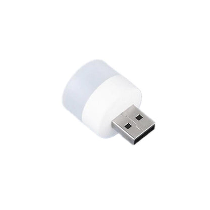 Wukusy USB LED night light plugged into a laptop, compact portable mini LED lamp illuminating a workspace.