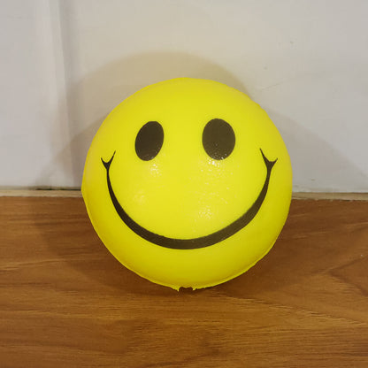 Soft foam smiley toy ball by Wukusy, bright yellow with a cheerful smile, perfect for play and sensory fun for children.