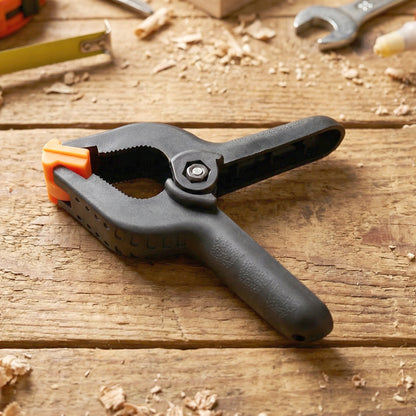 Heavy-duty Wukusy spring clamp shown gripping a piece of wood, ideal for woodworking and DIY projects.