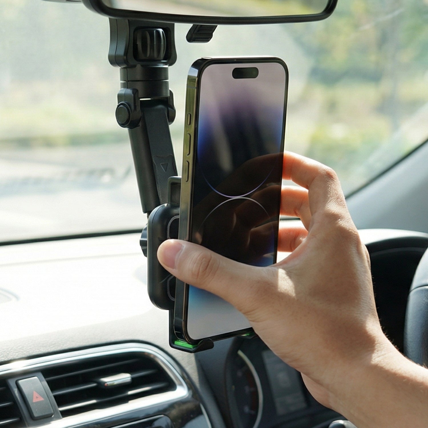 Wukusy 360-degree adjustable car rearview mirror phone holder mounted on vehicle mirror, holding a mobile phone securely.