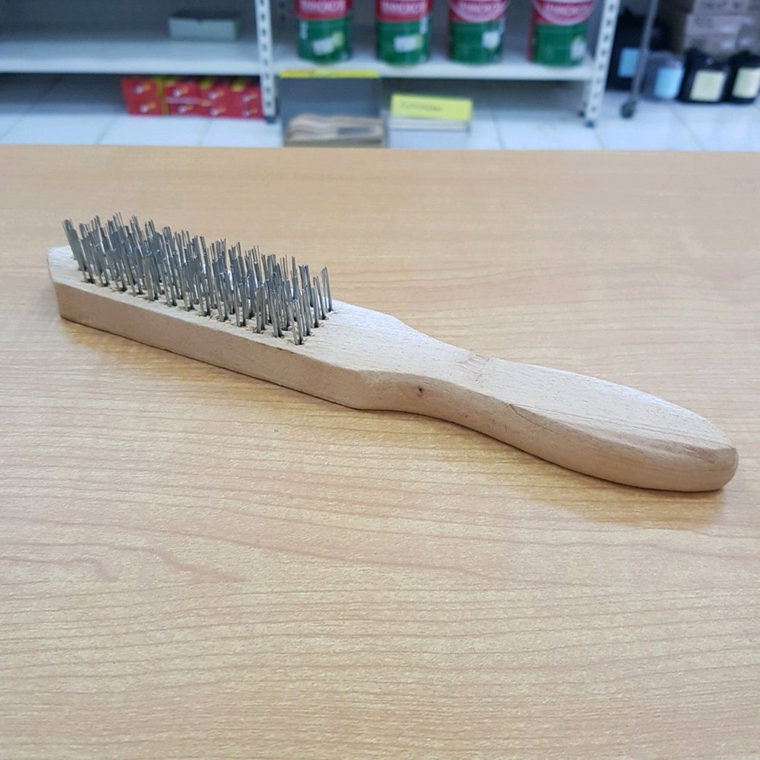 Steel wire brush with wooden handle by Wukusy, ideal for cleaning and rust removal, shown with sturdy metal bristles.
