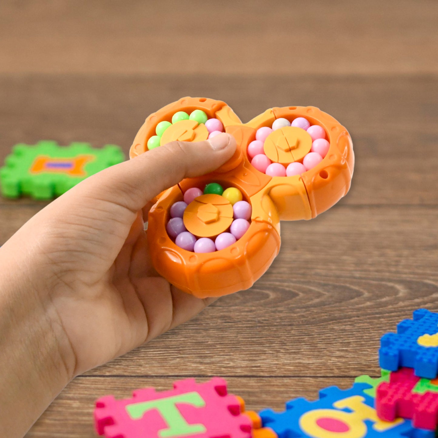 Wukusy Aditi 3-in-1 interactive spinny twist puzzle ball toy for children, featuring colorful rotating parts and textured surfaces.