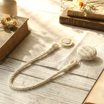 Elegant magnetic curtain tieback by Wukusy holding draped curtains with a sleek metallic finish.