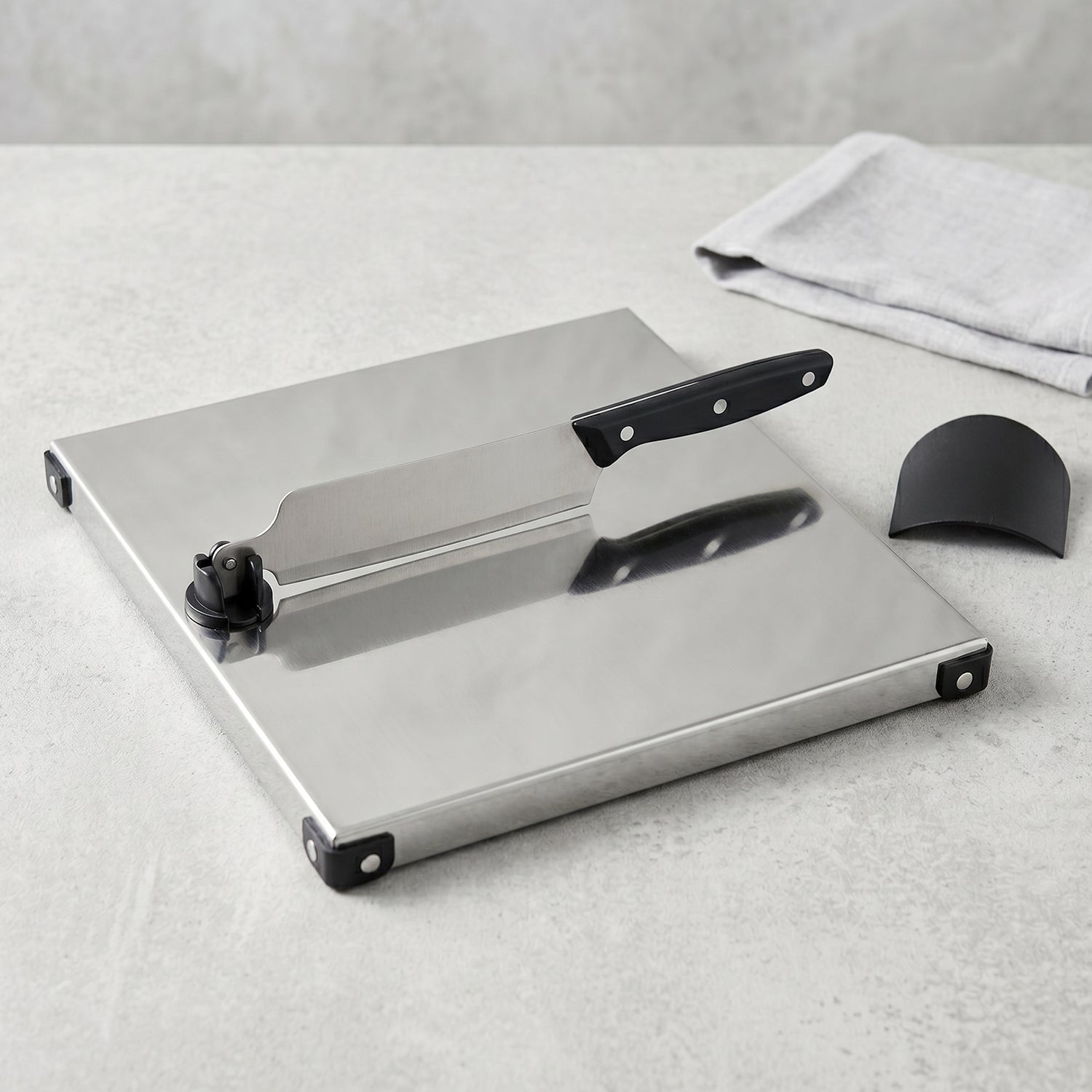 Wukusy stainless steel 2-in-1 cutting and chopping board with built-in knife, shown with the board and knife ready for food prep