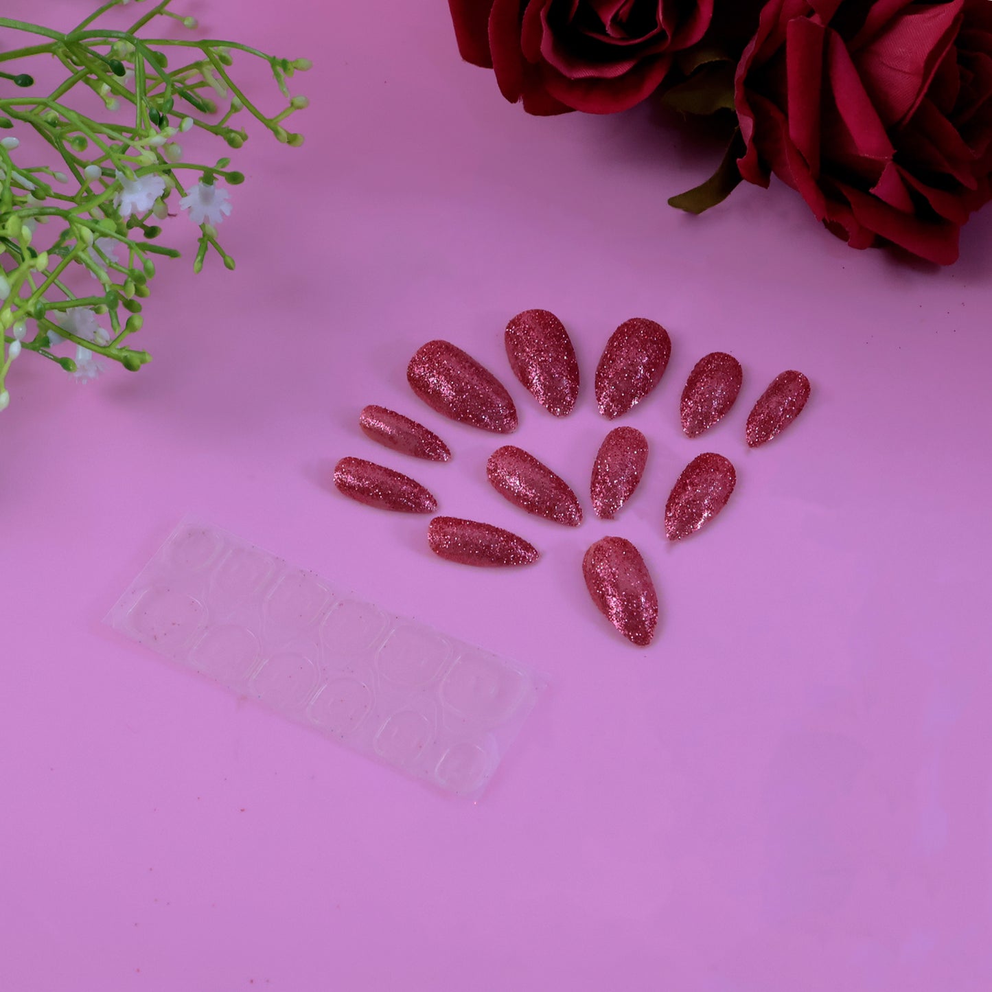 Set of Wukusy glitter press-on false nails with mixed colors and designs, showcasing shiny, stylish nail art on a natural hand.
