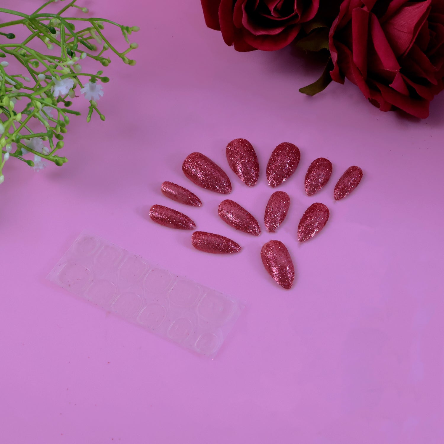 Set of Wukusy glitter press-on false nails with mixed colors and designs, showcasing shiny, stylish nail art on a natural hand.