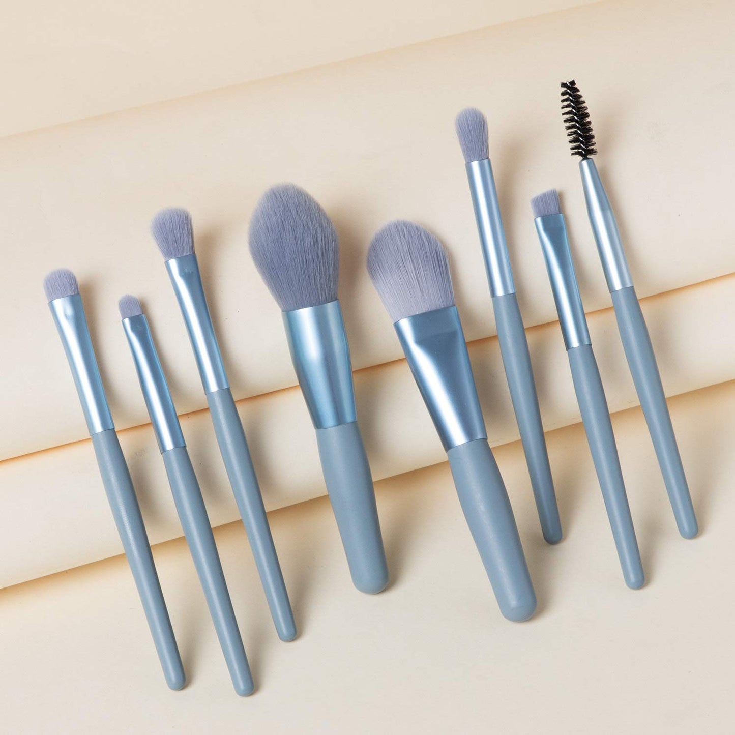 Wukusy 8-piece mini makeup brush set with case, includes foundation, blush, eyeshadow, and lipstick brushes with synthetic bristles.