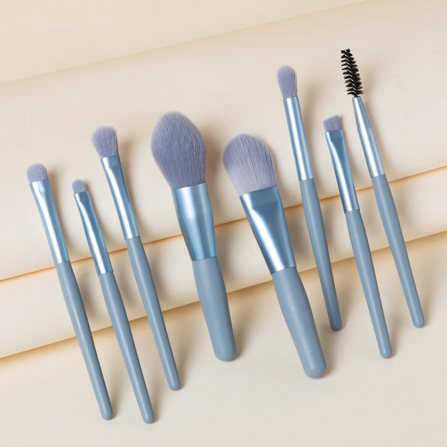 Wukusy 8-piece mini makeup brush set with case, includes foundation, blush, eyeshadow, and lipstick brushes with synthetic bristles.