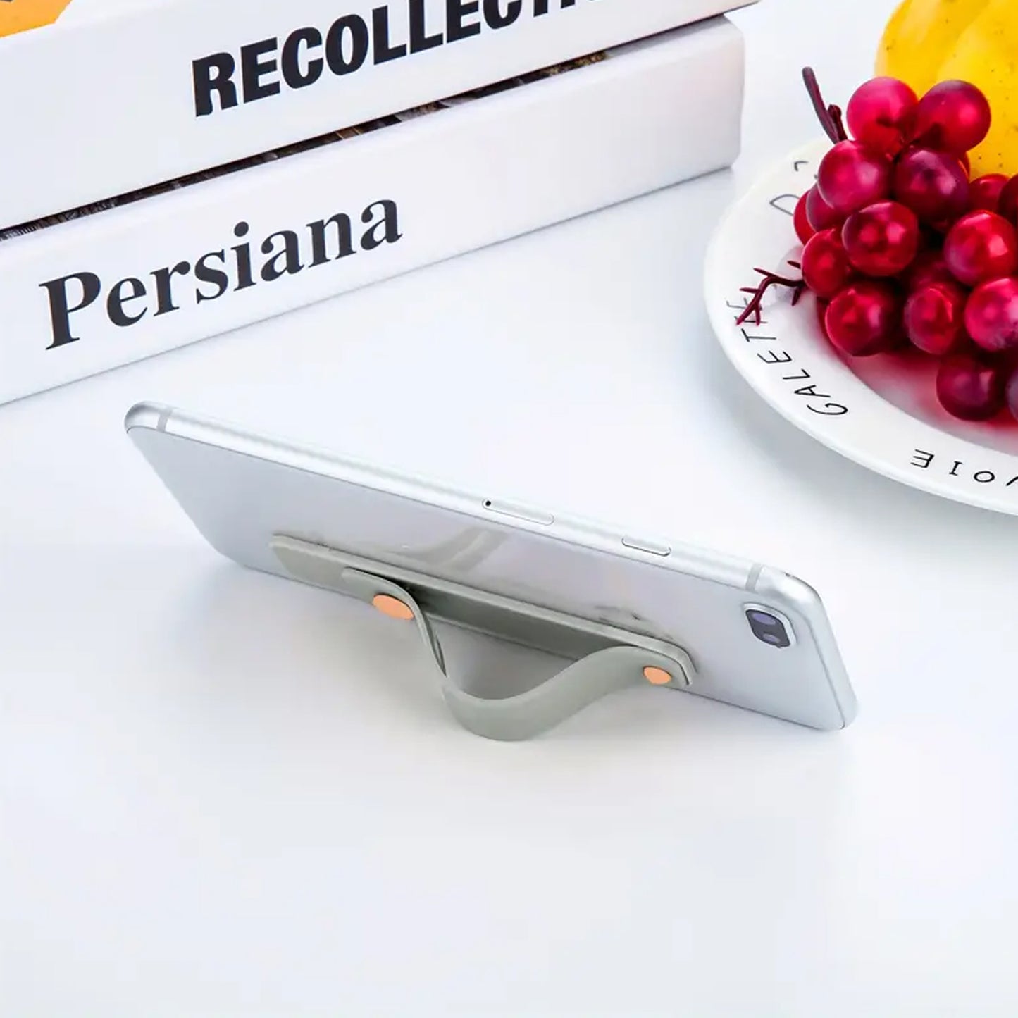 Silicone phone loop finger holder grip strap by Wukusy, showing a flexible, colorful strap attached to a smartphone for secure handling.