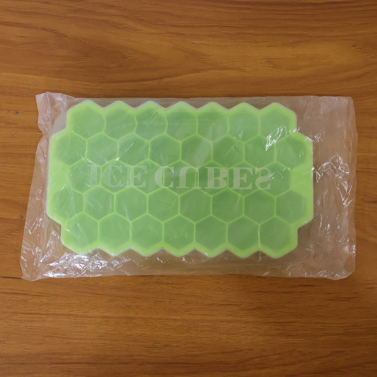 Wukusy premium honeycomb silicone ice cube tray with lid showing multiple ice cubes in a clear tray on a kitchen countertop