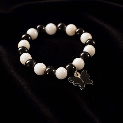 Elegant black and white fancy bracelet by Wukusy featuring intricate design and stylish appearance, displayed on a neutral background.