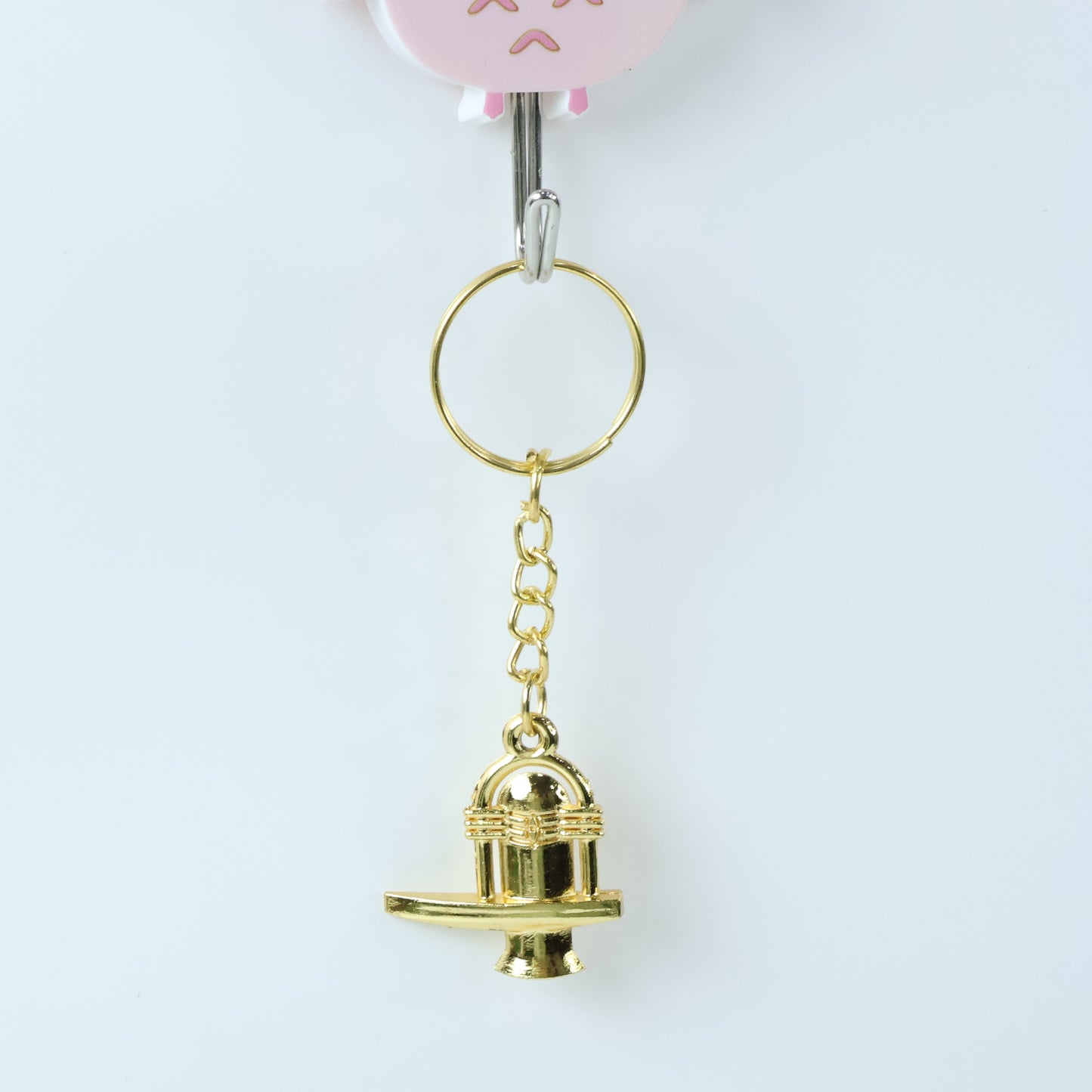 Golden metal Shivling keychain from Wukusy, featuring intricate design, ideal for spiritual accessories or key organization.