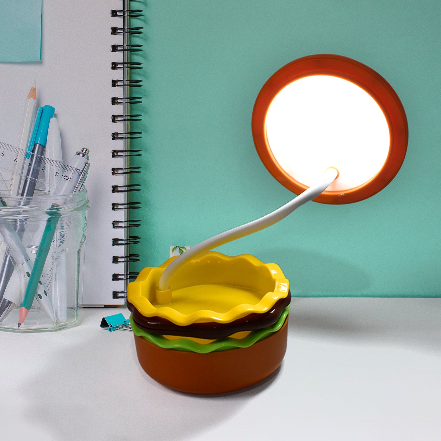 Wukusy Burger Delight folding LED night lamp, shaped like a burger, glowing softly with adjustable brightness in a cozy room setting.