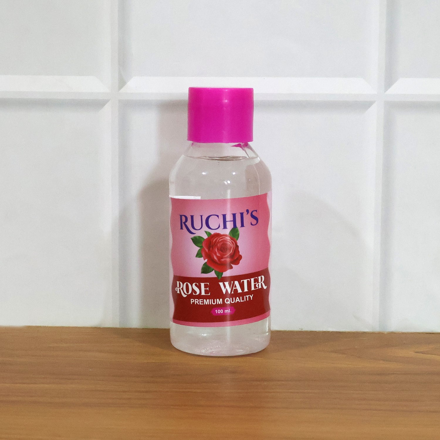 Wukusy premium rose water skin toner and face mist in a 100ml spray bottle, with rose petals and mist spray visible.