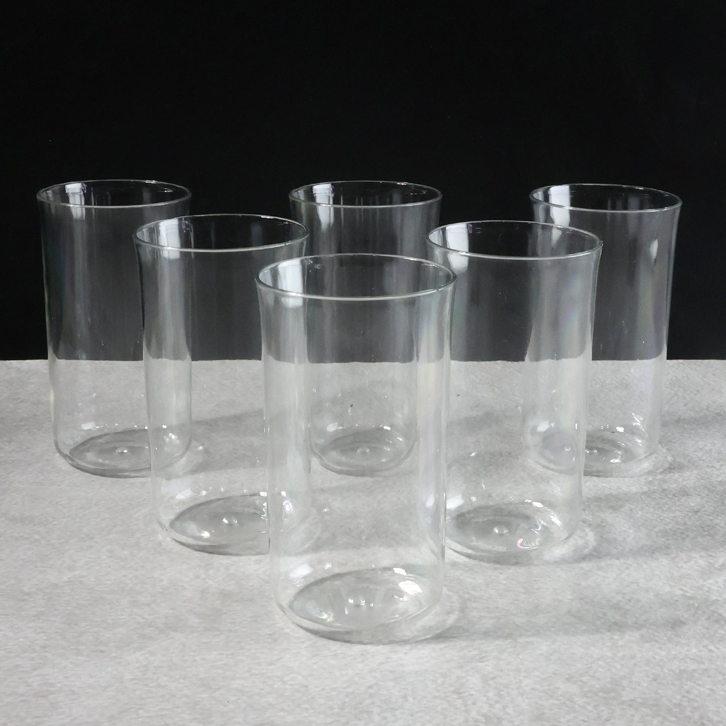 Six glossy plastic drinking glasses by Wukusy, 300 ml each, arranged on a kitchen countertop for home use.