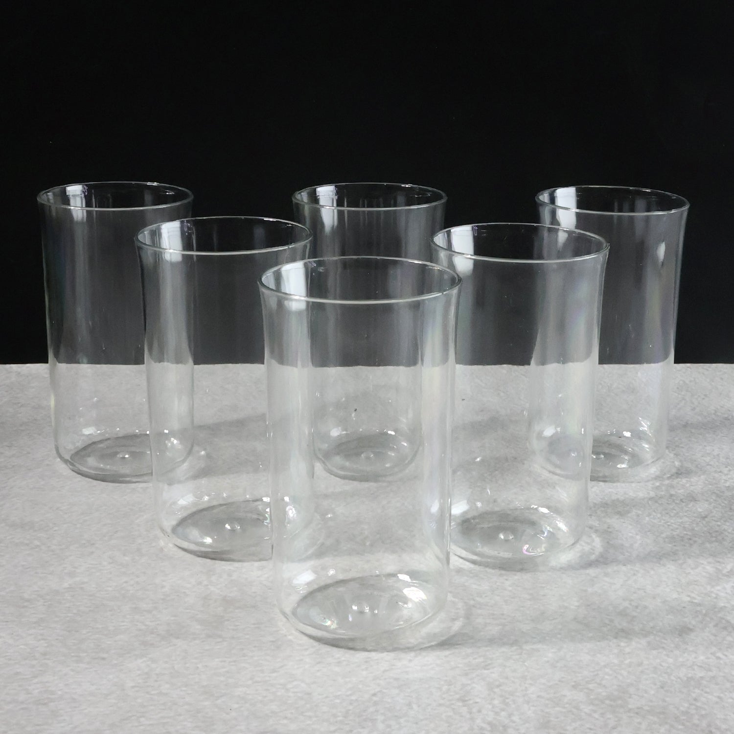Six glossy plastic drinking glasses by Wukusy, 300 ml each, arranged on a kitchen countertop for home use.