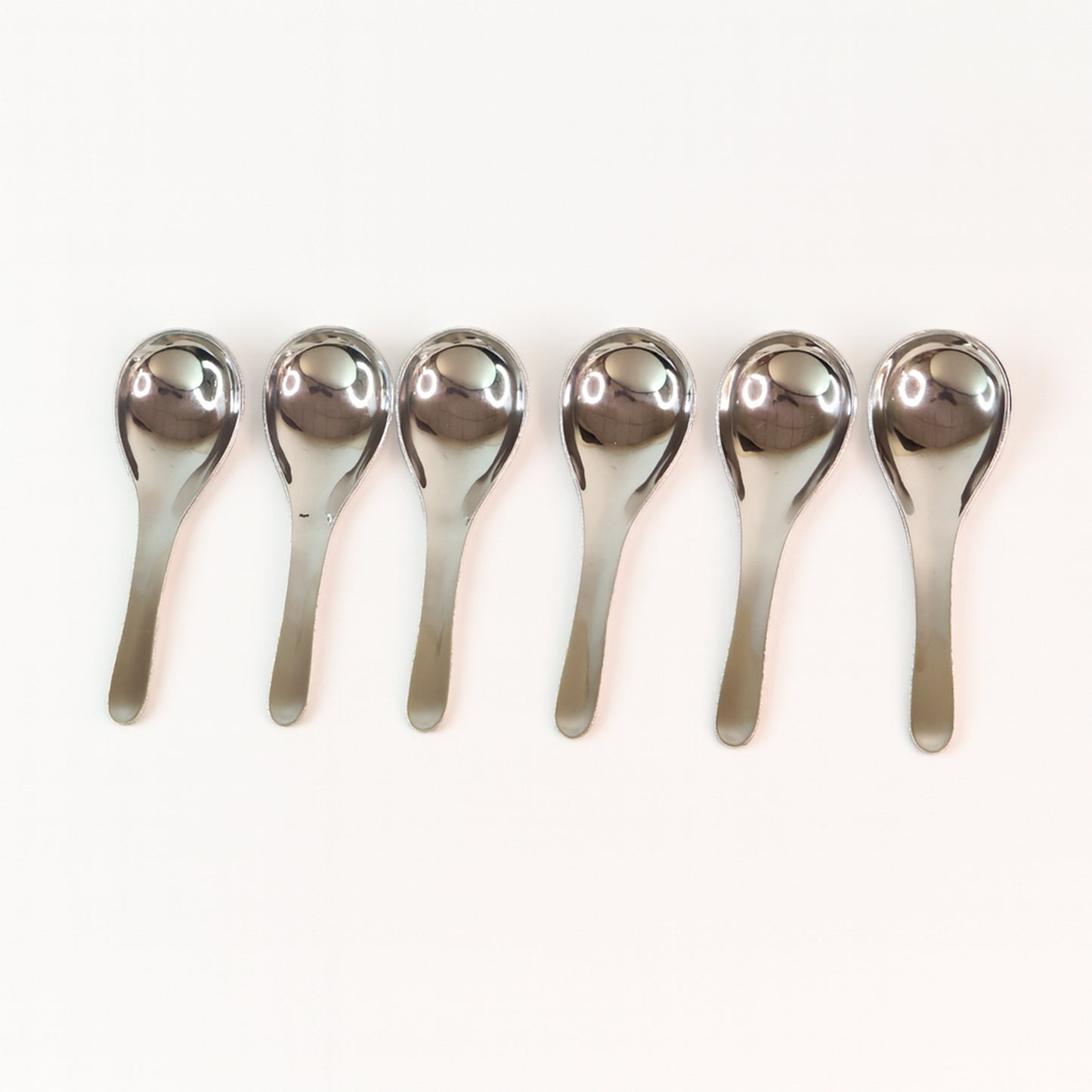Six Wukusy Apex premium stainless steel soup spoons arranged in a set, showcasing their polished, durable design for home and kitchen use.