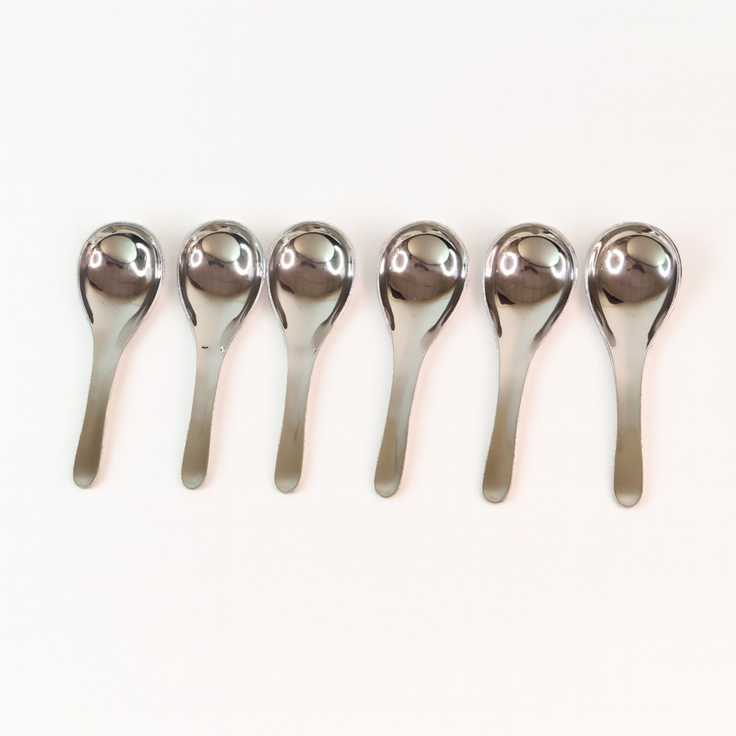 Six Wukusy Apex premium stainless steel soup spoons arranged in a set, showcasing their polished, durable design for home and kitchen use.