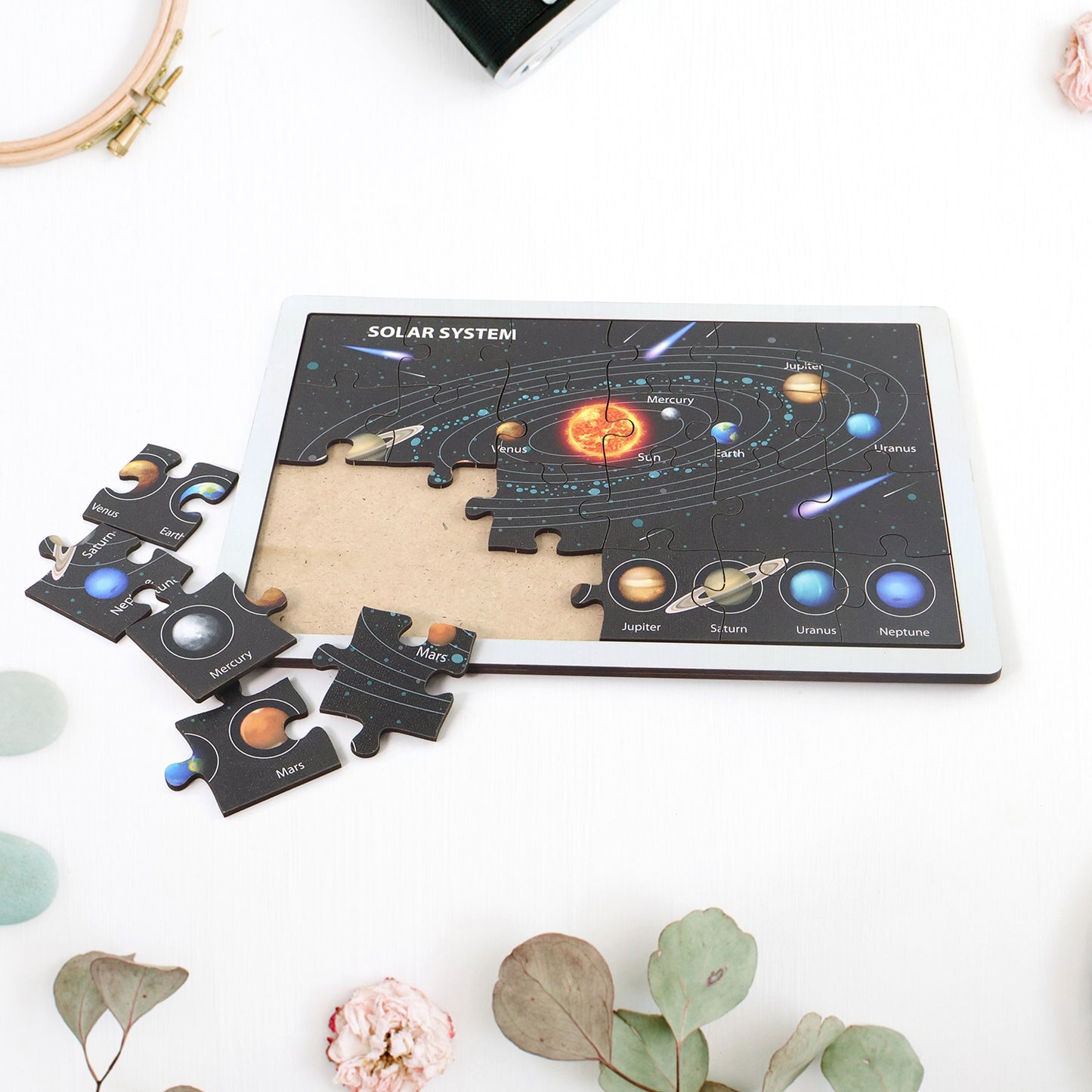 Wooden solar system puzzle for kids by Wukusy, featuring colorful planets and space-themed pieces in a educational toy set.
