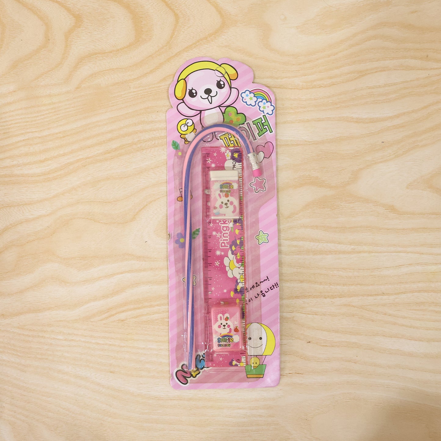 Pink Wukusy 4-in-1 stationery set with ruler, pencil, eraser, and sharpener on a white background.