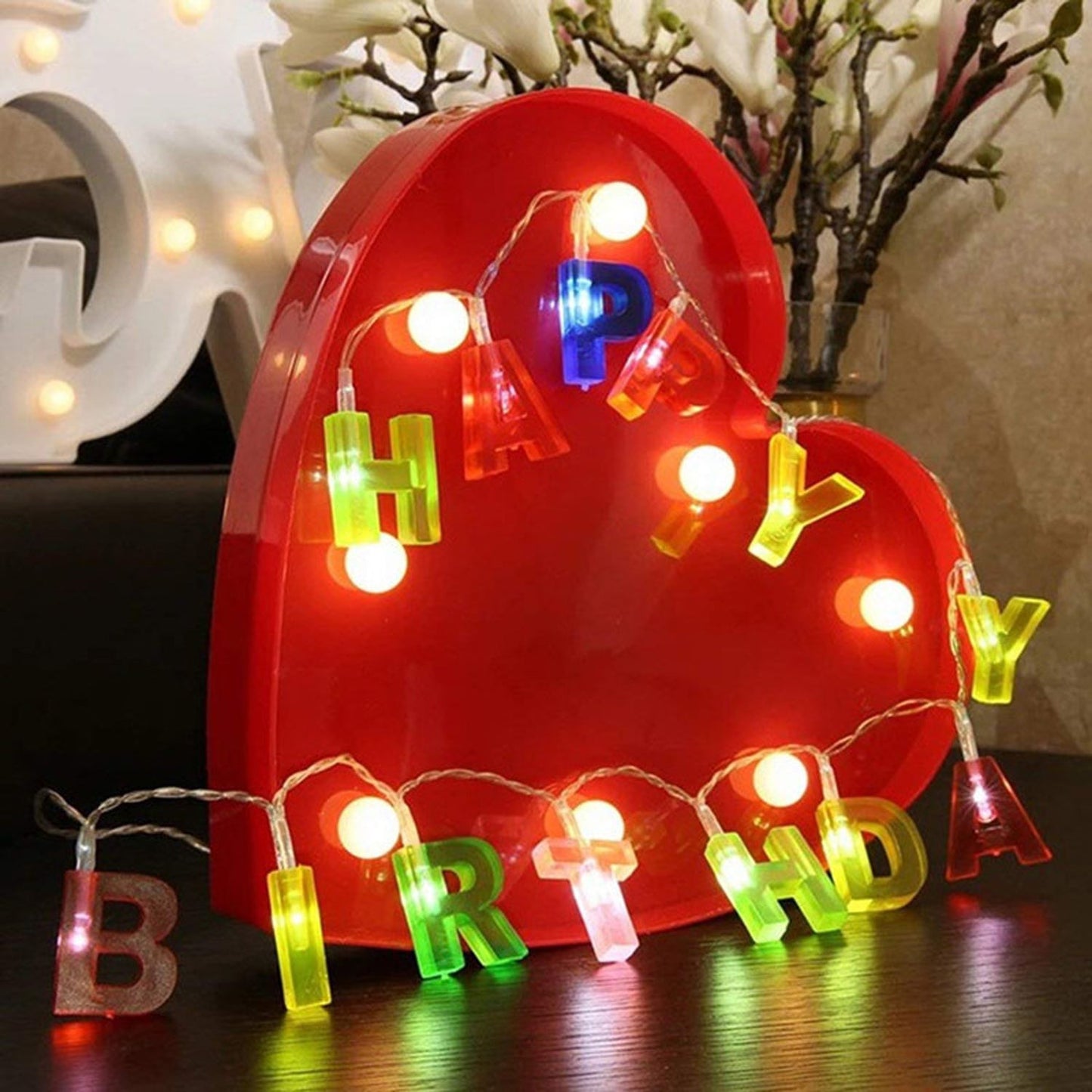 Colorful plastic "Happy Birthday" LED string lights by Wukusy, battery-operated outdoor home decor with 13 multicolour letter lights.