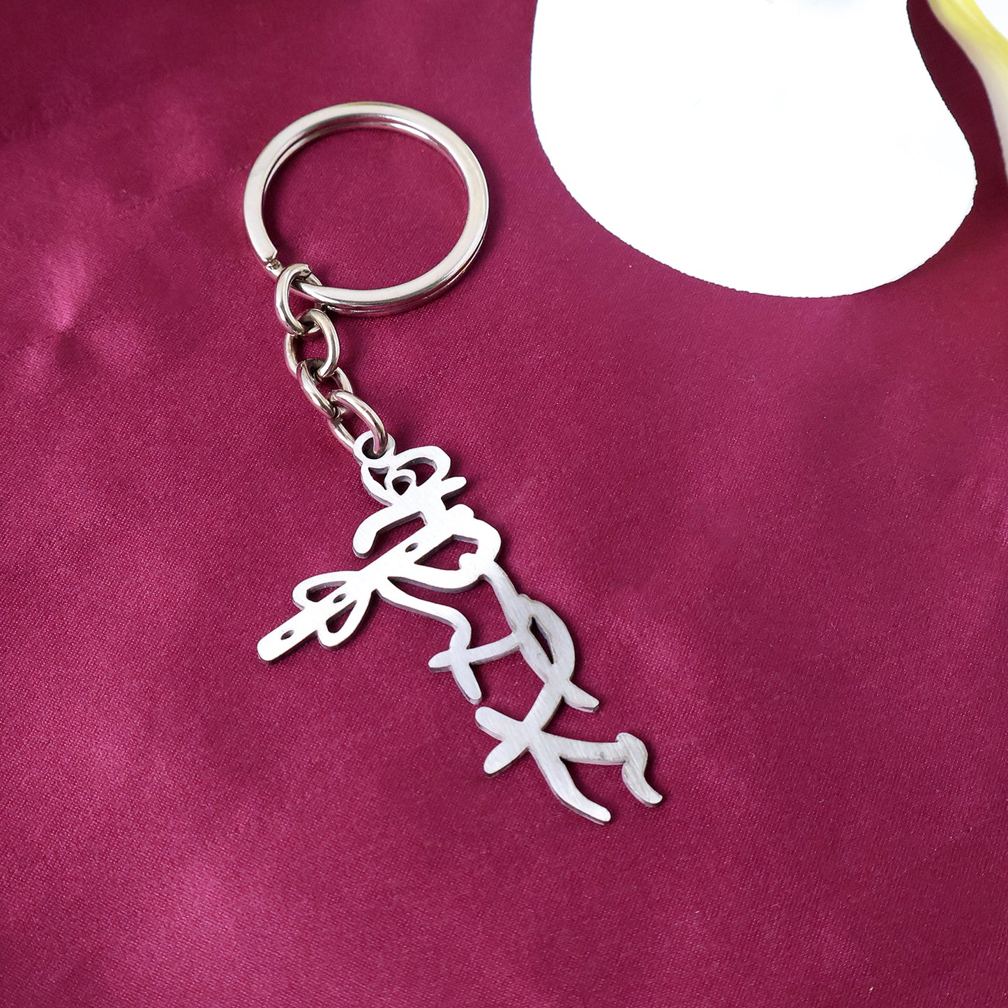 Metal keychain featuring a Divine Krishna flute design, styled with intricate details, by Wukusy.