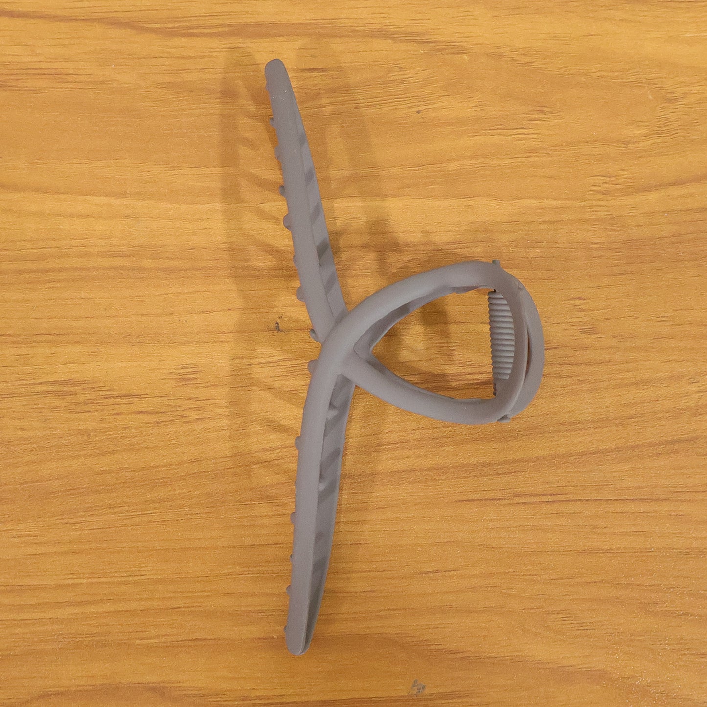 Large Wukusy strong grip hair claw clip holding thick hair, showcasing its sturdy design and wide opening.