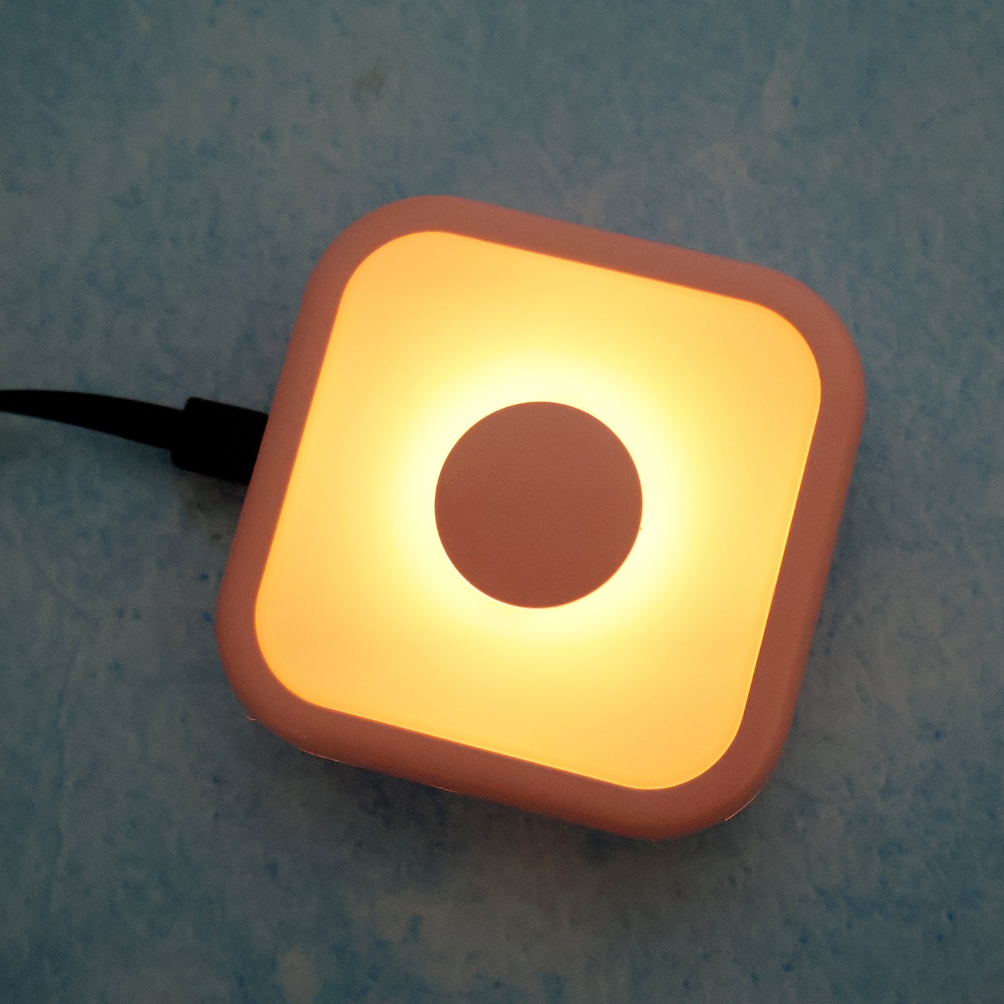 Wukusy portable USB-powered touch sensor LED night lamp illuminating a bedside table in a home setting.