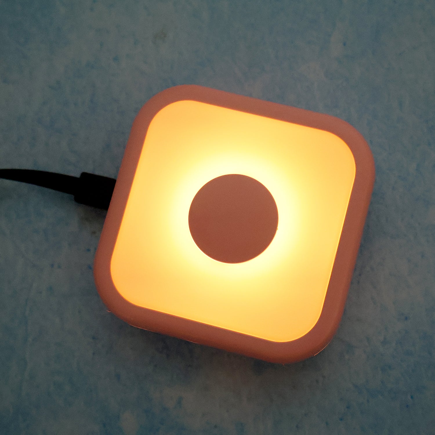 Wukusy portable USB-powered touch sensor LED night lamp illuminating a bedside table in a home setting.