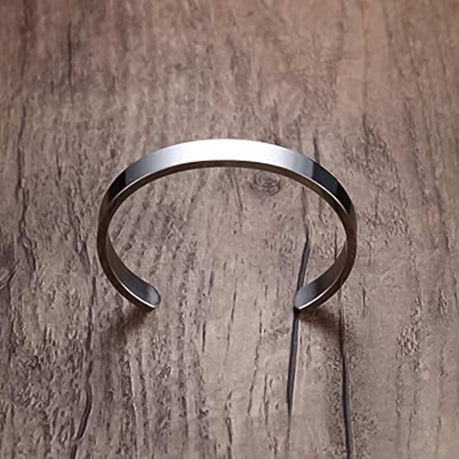 Silver-tone stainless steel minimalist open-ended kada bracelet by Wukusy, polished fashion accessory with sleek, modern design.