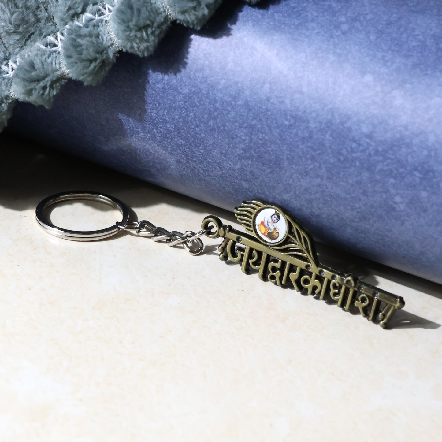 Metal keychain featuring Jai Dwarkadhish design, branded by Wukusy, displayed with intricate detailing and a keyring attachment.