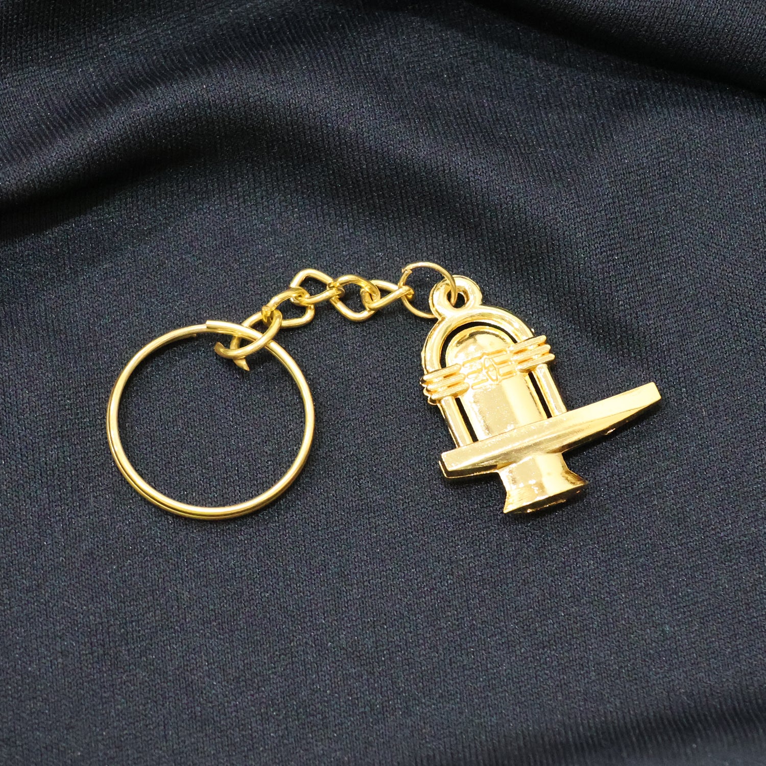 Golden metal Shivling keychain from Wukusy showing detailed Shivling design on a small, decorative keychain.