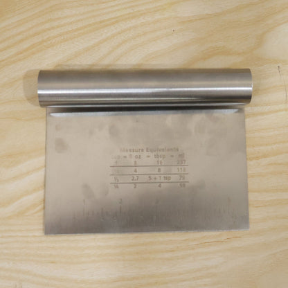 Small stainless steel dough scraper cutter with scale, 15x12 cm, by Wukusy, showing the tool with measurement markings.