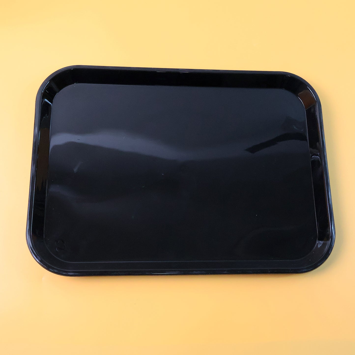 Black plastic serving tray plate, 40x30 cm, from Wukusy, shown with a smooth surface and raised edges for serving food.