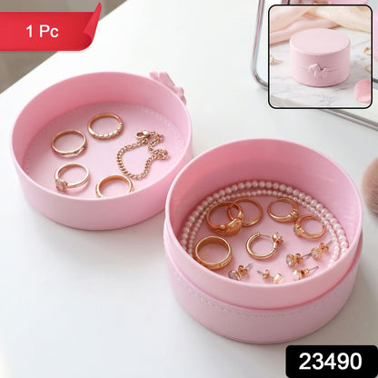Small round Wukusy jewelry storage box with snap closure, portable organizer case for necklaces, rings, and earrings.