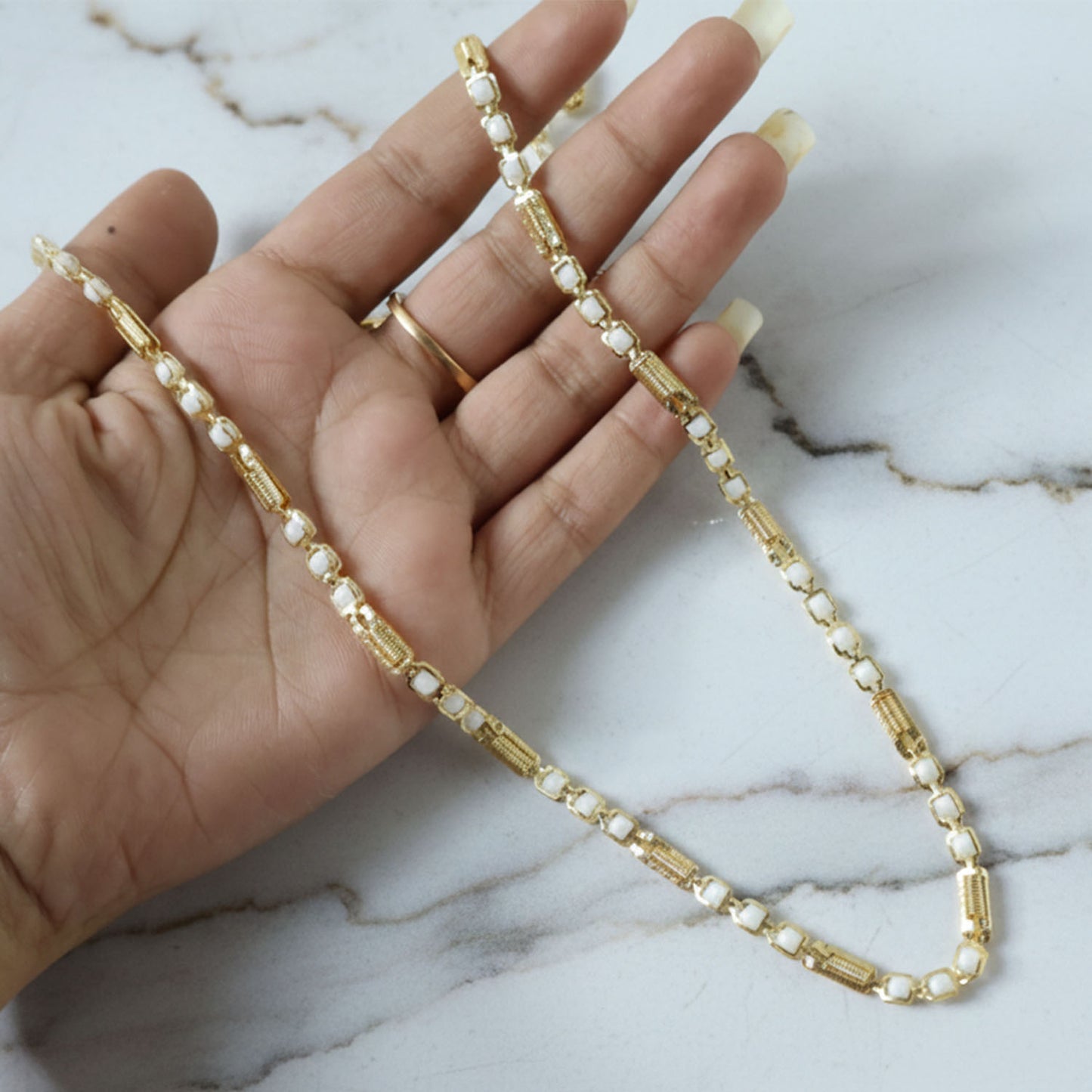Gold-tone designer chain necklace by Wukusy, showing close-up of the elegant, shiny chain with detailed links.