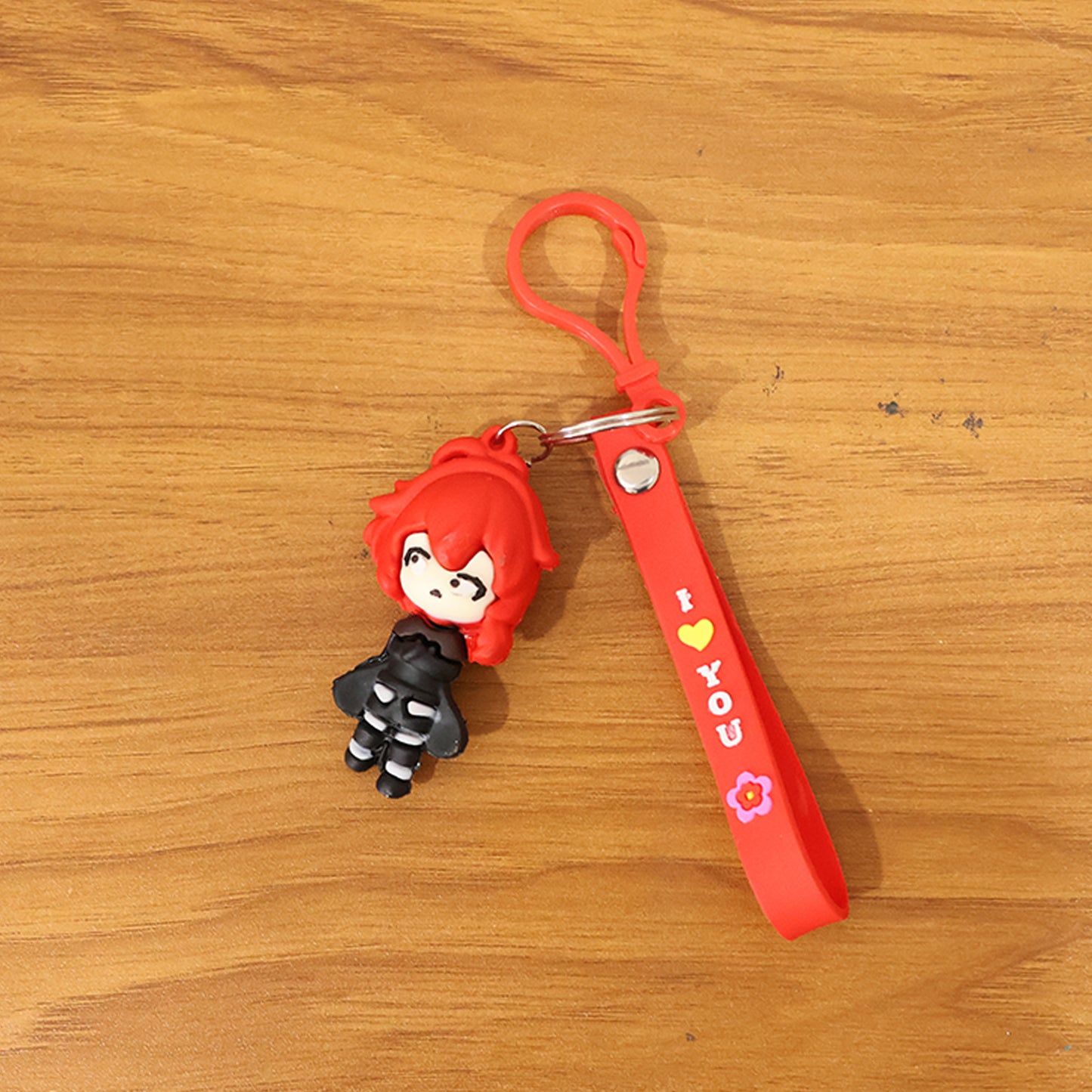 Red-haired cartoon girl silicone keychain featuring a cute girl design, ideal for keys or bags, by Wukusy.