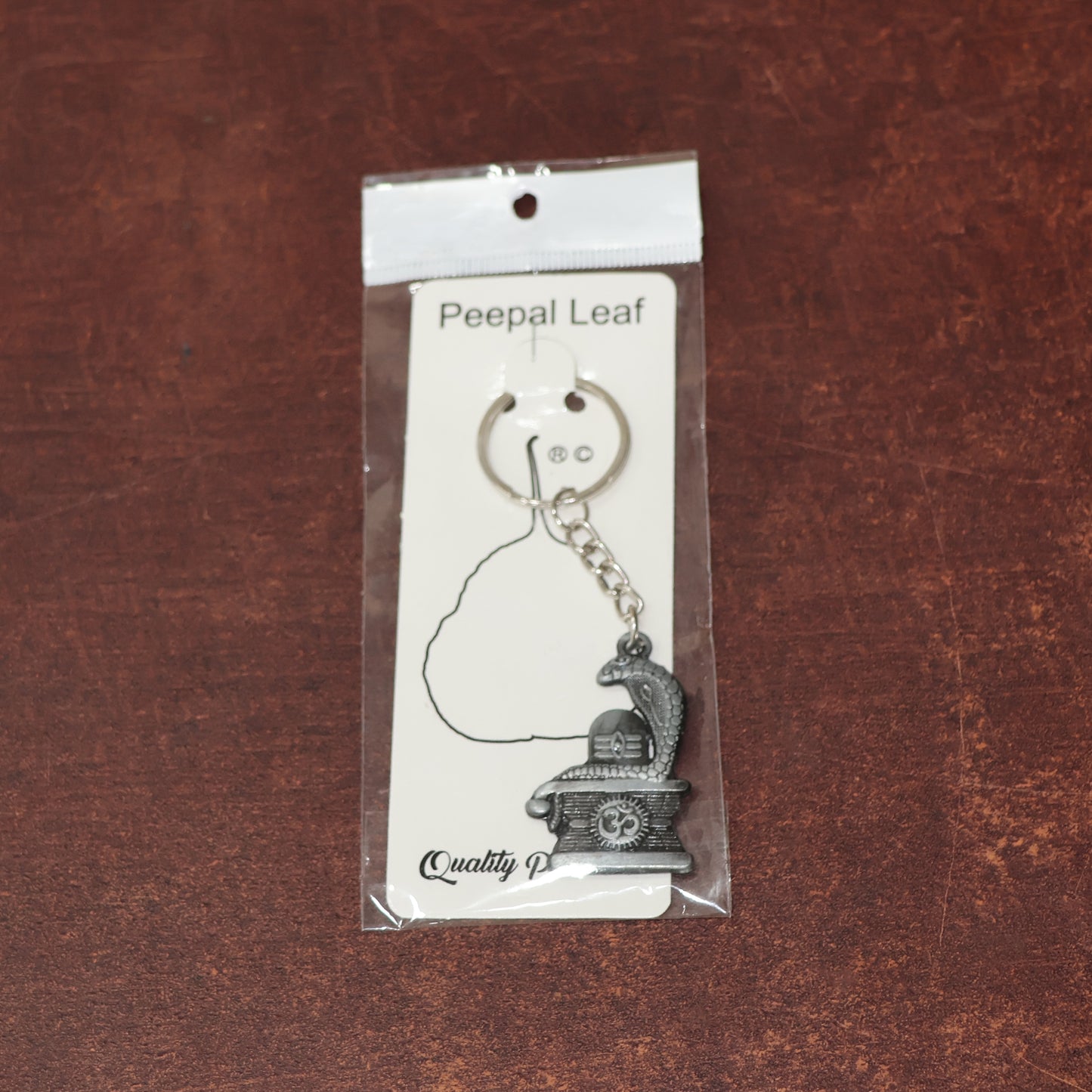 Silver Shivling keychain with snake design by Wukusy, featuring intricate details on a small, decorative jewelry accessory.