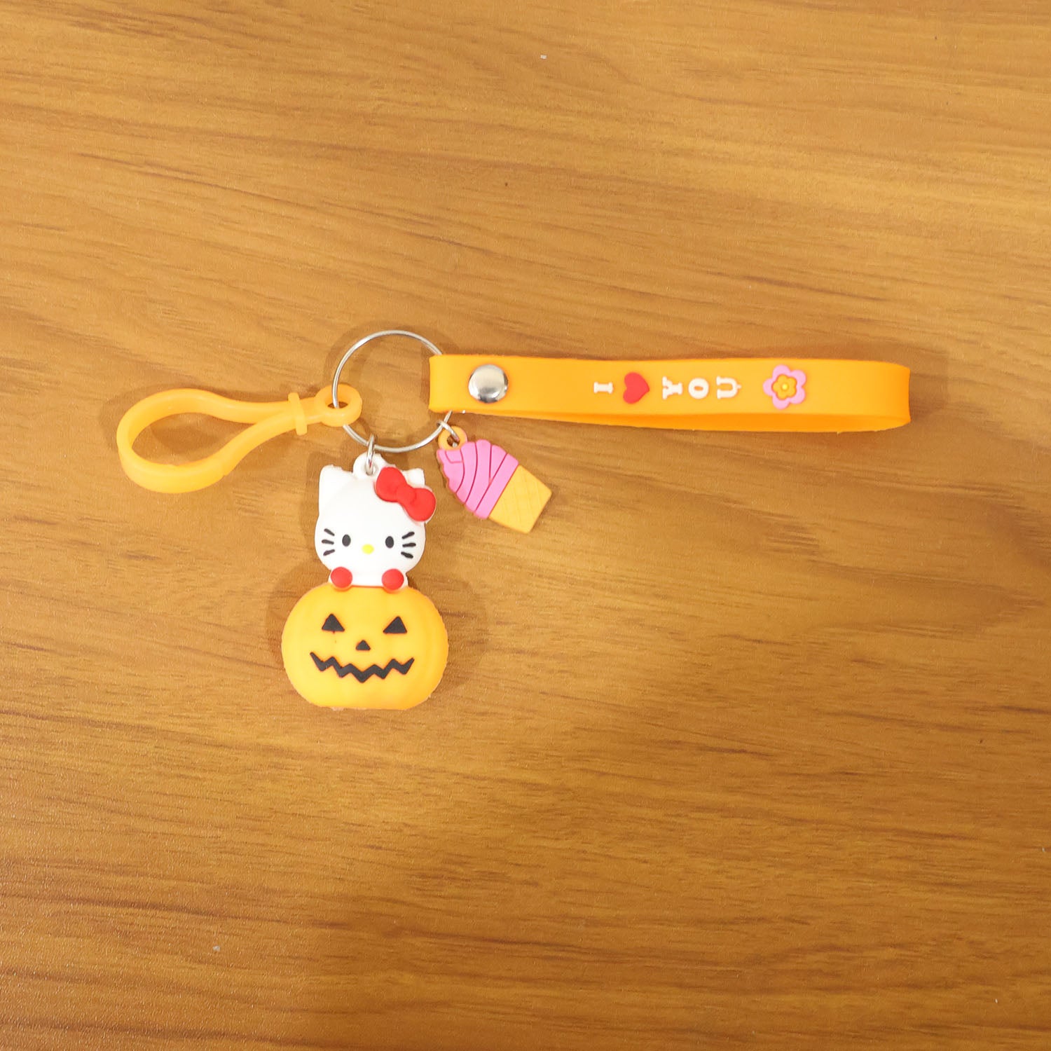 Cute cartoon kitty and pumpkin keychain by Wukusy, featuring a colorful, playful design on a small accessory.