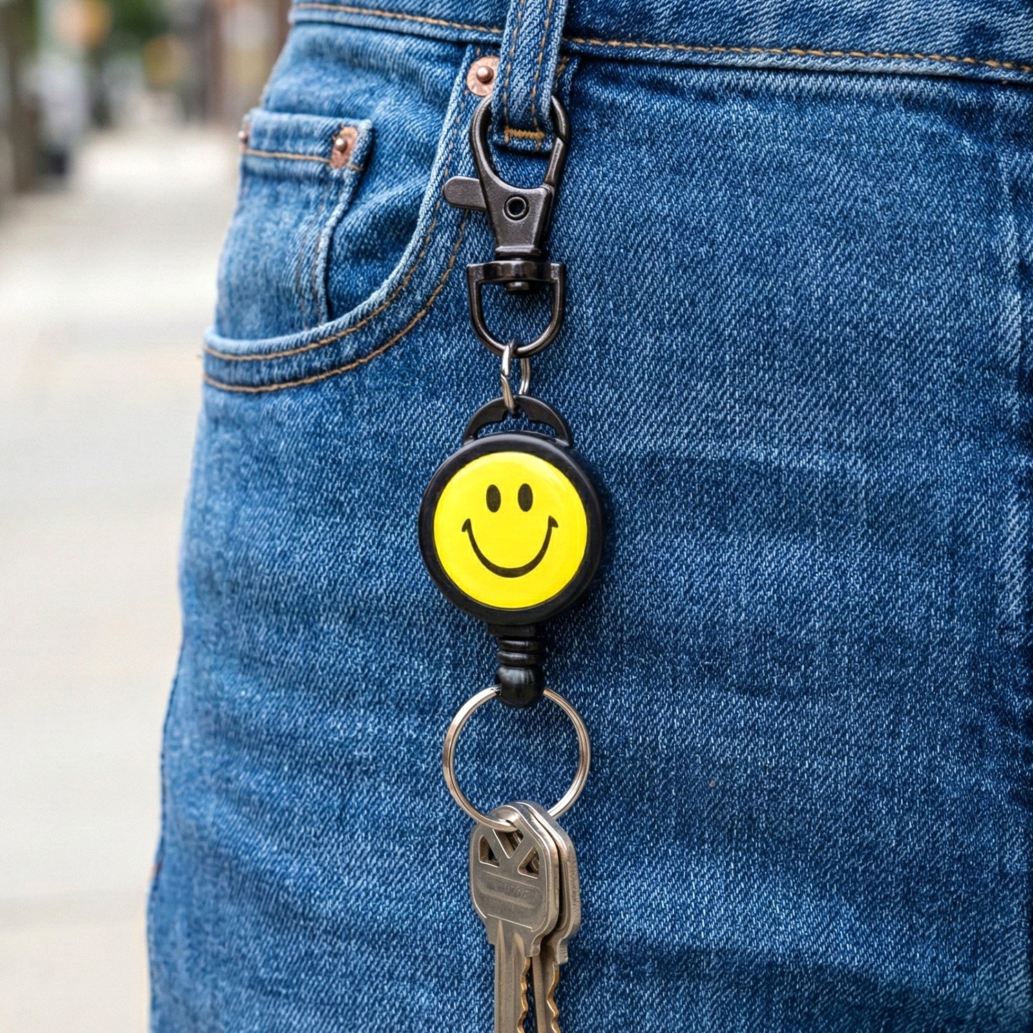 Wukusy smiley face retractable keychain with cheerful yellow smiley design and silver clip, perfect for holding keys or ID cards