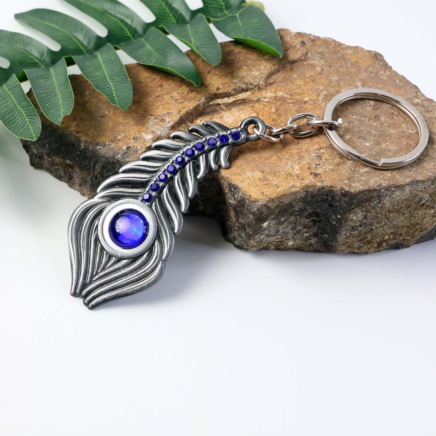 Wukusy elegant metal peacock feather keychain showcasing detailed feather design on a keyring.