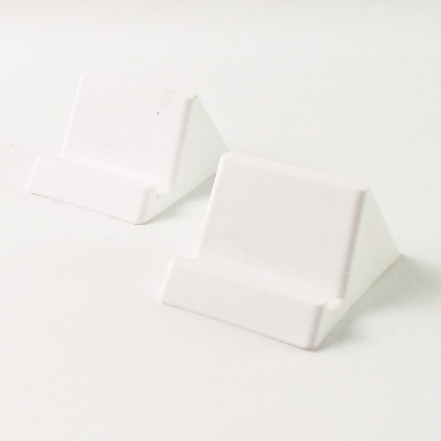 Two Wukusy compact plastic mobile phone holder stands in mixed colors, designed for hands-free support and easy viewing.