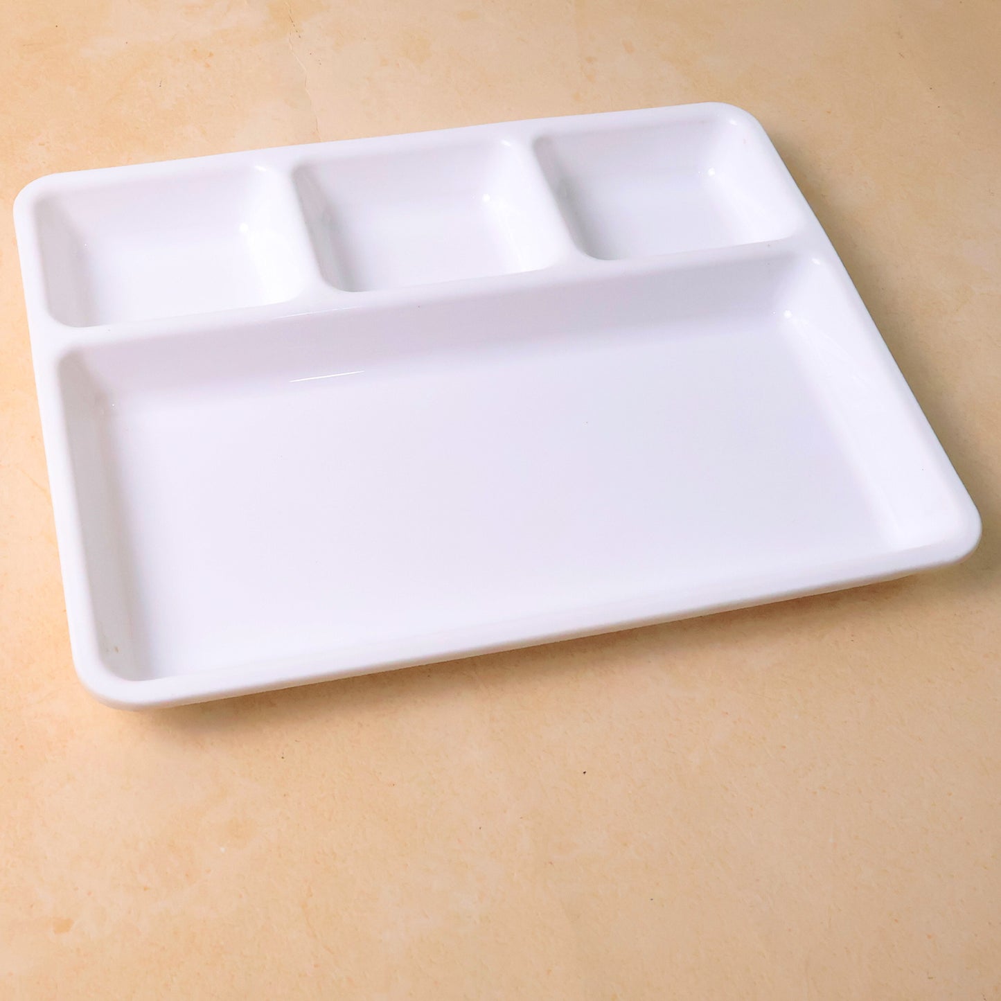 White plastic 4-compartment rectangular meal serving tray from Wukusy, ideal for home and kitchen use.