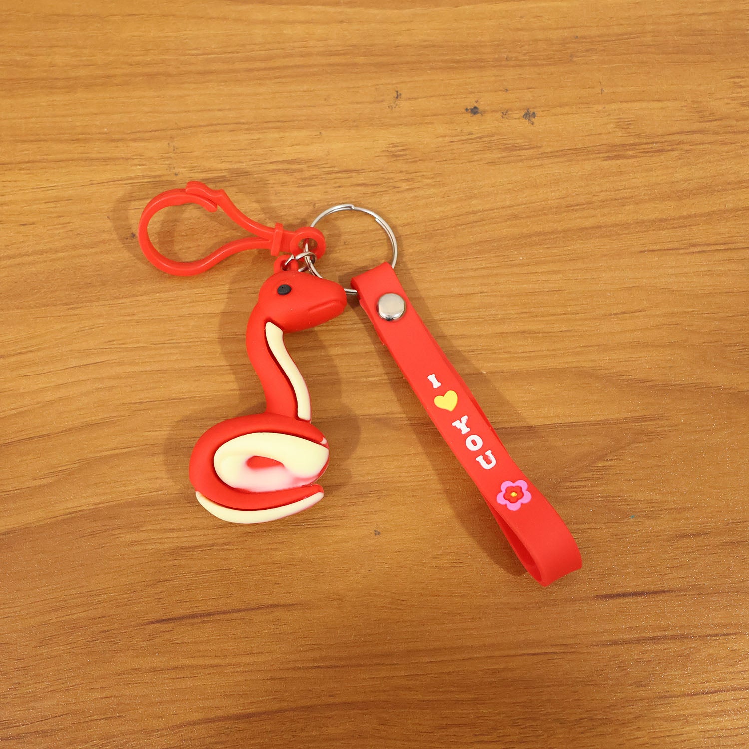 Cute cartoon snake keychain by Wukusy featuring a colorful, playful snake design on a metal keyring.