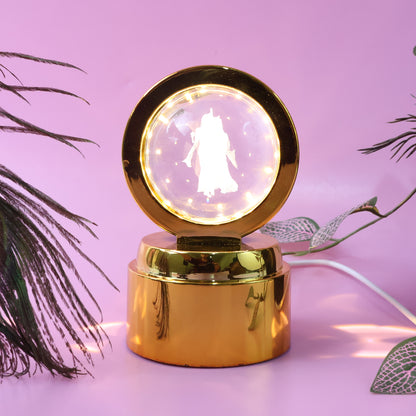 Wukusy Radhe Krishna crystal ball night light on office desk, illuminated crystal sphere with intricate Krishna design.