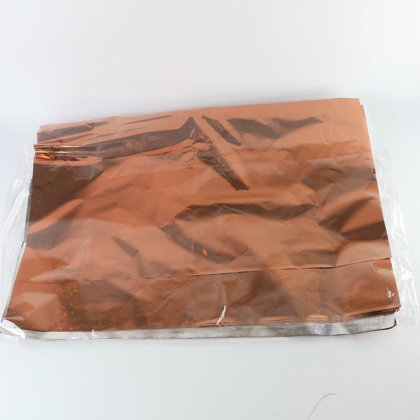 Assorted metallic gift wrapping paper sheets in mix colors, 70x50 cm, from Wukusy, displayed in a stack.