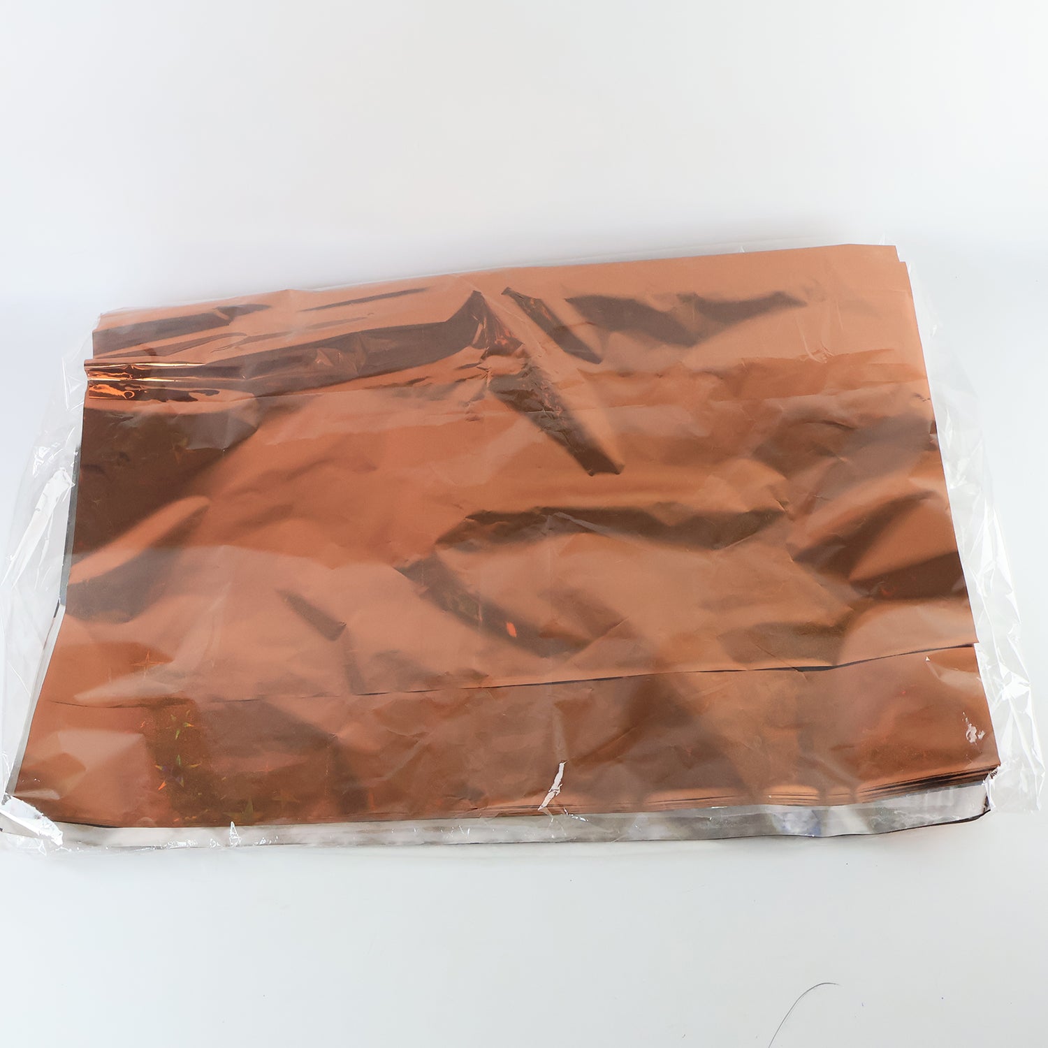 Assorted metallic gift wrapping paper sheets in mix colors, 70x50 cm, from Wukusy, displayed in a stack.